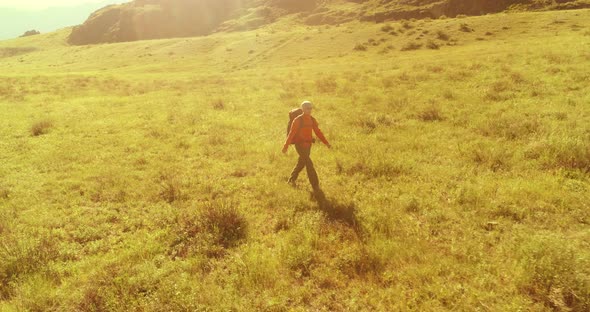 Flight Over Backpack Hiking Tourist Walking Across Green Mountain Field alt