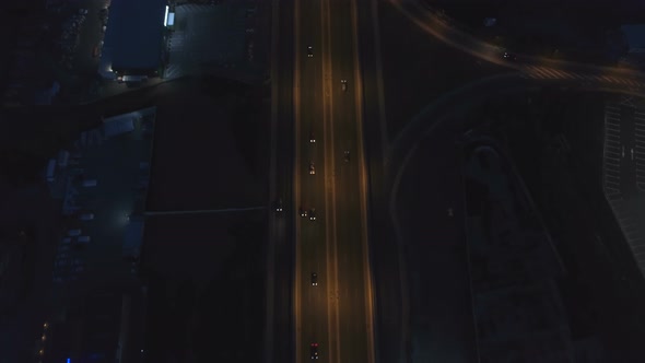 Road Intersection with Roundabout and City Traffic in the Night alt