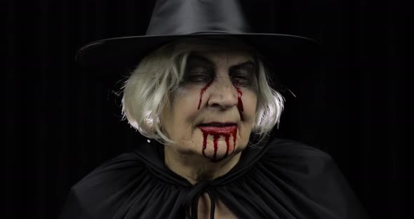 Old Witch Halloween Makeup. Elderly Woman Portrait with Blood on Her Face alt