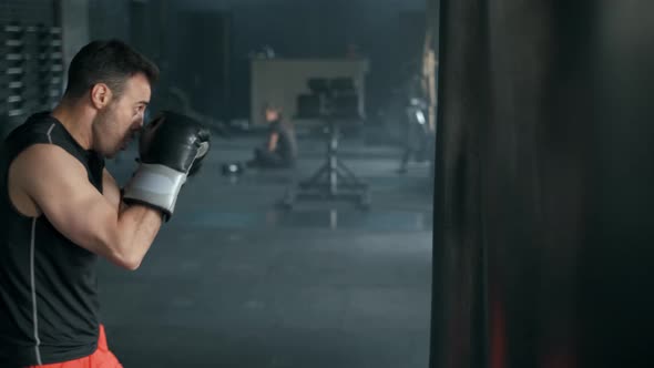 Aggressive Professional Fighter Is Training with a Punching Bag, Inflicting a Furious Blow. The alt