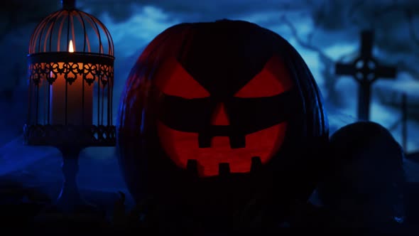 Scary laughing pumpkin and an old skull over the frightening gothic background. alt