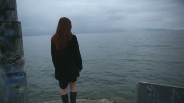 Teenage girl sad, alone, in front of a lake