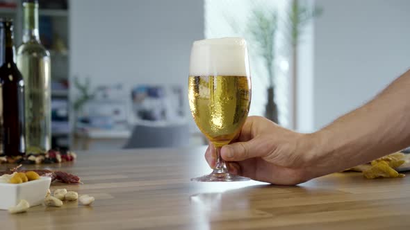 Hand Putting Glass Of Beer On Table