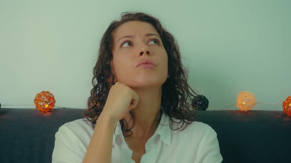 Portrait of a Young Woman Putting Her Finger to Her Face Remembering or Thinking About Some Idea alt