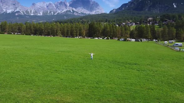 Camera Revolving Around Woman Enjoying the Beauty of Dolomites in the Background alt