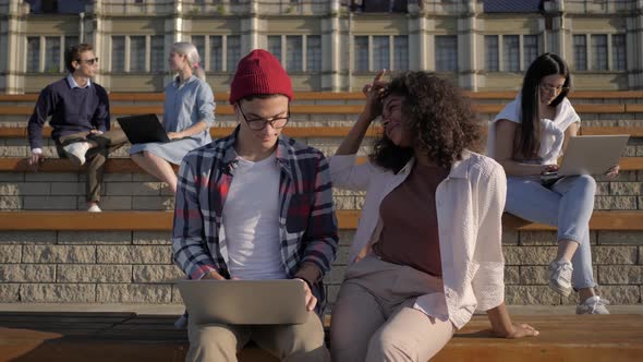 Young Students Working with Laptop Computers Outdoors. alt