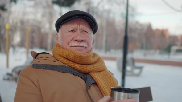 Senior Man Drinking Hot Tea in Park alt