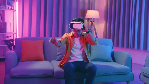 Young Asian Man Explores Virtual Reality At Living Room, Cyan And Magenta Colours alt
