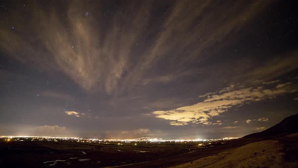 Time lapse of the nights sky over city lights as stars move overhead alt