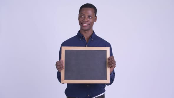 Young Happy African Businessman Holding Blackboard alt