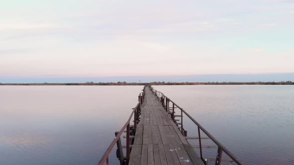 Calm tranquil water surface on estuary at sunrise with bridge alt