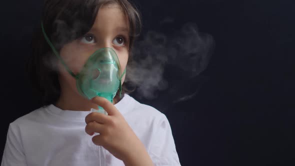 Boy Child Breathes Inhalation Through a Mask is Treated for Allergies alt