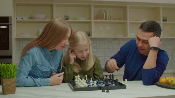 Joyful Hearing Impaired Family and Preadolescent Girl Playing Chess Game at Home alt