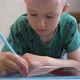 A school-age boy draws with a stylus on a digital tablet - VideoHive Item for Sale
