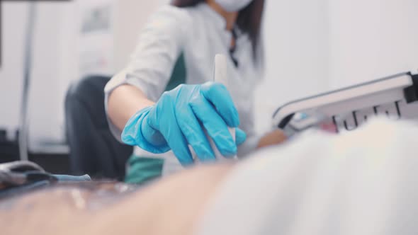 Doctor Doing Abdominal Ultrasound to a Man in a Modern Clinic