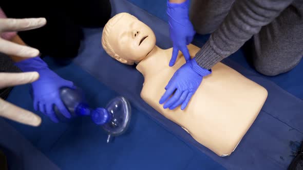 Training on a medical mannequin doll. Learning to do chest compression on a dummy. alt