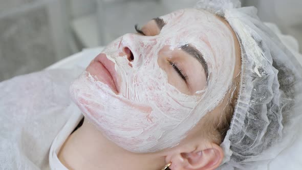 Girl Lies on the Table at the Doctor Beautician with White Cream alt