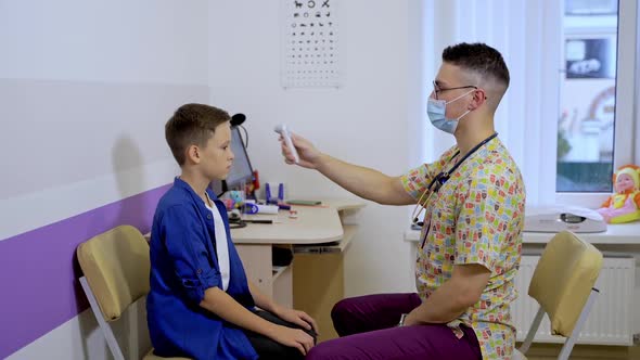 Male pediatrician consulting teenage boy at clinic alt