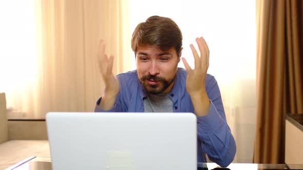 Young Stressed Handsome Man Working in Living Room Shouting at Laptop Screen and Being Angry alt