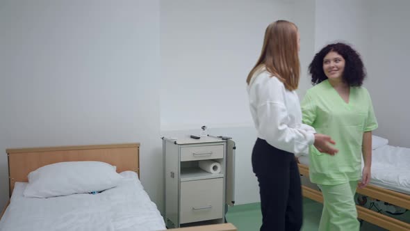 Caucasian Doctor and Patient Talking Walking Out of Hospital Ward Indoors alt