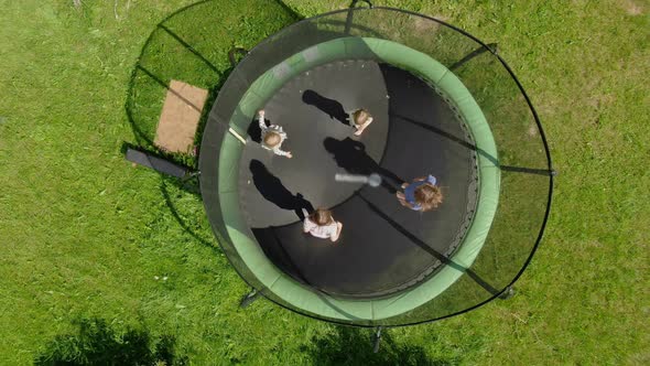Aerial Shooting of a Little Girls Company Jumping and Running on the Trampoline alt