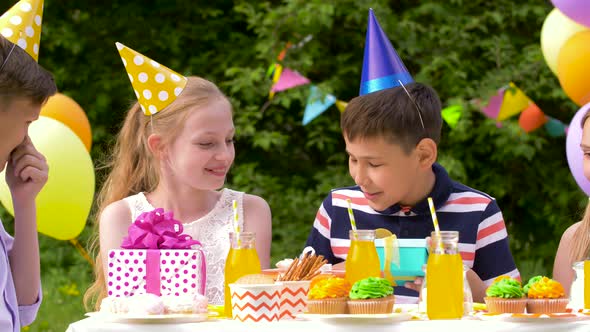 Kids Giving Presents To Birthday Boy at Party  alt