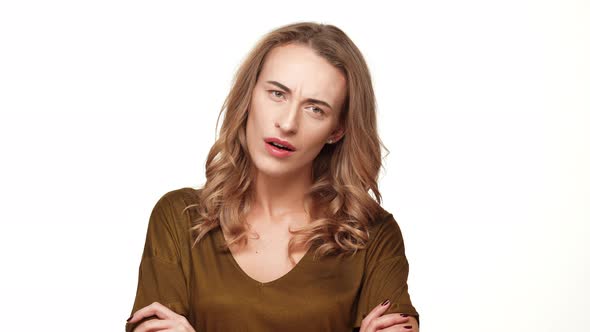 Displeased Middleaged Caucasian Female with Long Brown Hair Standing with Folded Hands on White alt