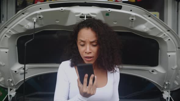 Young woman calling to mechanic with smartphone while car trouble and breakdown with angry. alt