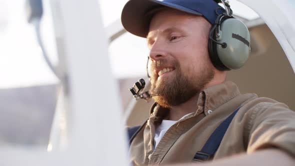 Aircraft Mechanic Sitting in Cockpit and Smiling alt