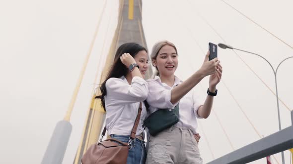 Happy Asian lesbian couples selfie video chat with friends enjoying traveling in Thailand.