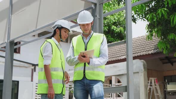 Asian colleague workers people wearing protective safety helmet working on construction side. alt