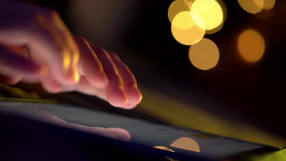 Close up shot of female hand using tablet touching and typing on screen.