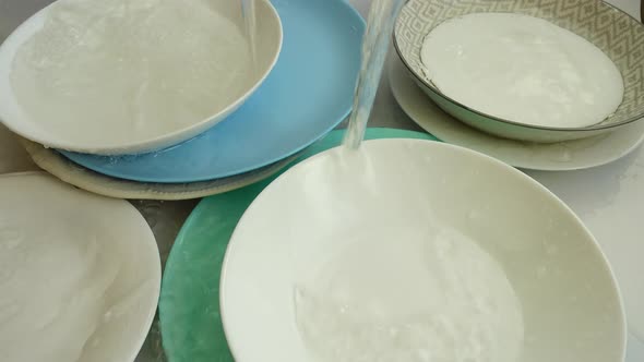 Washing dishes. Falling stream of water. alt