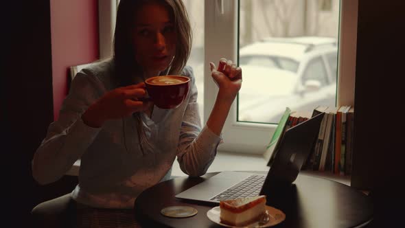 Woman Working on Laptop and Drinking Coffee