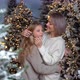 Mom and daughter hug and smile at each other standing in a snowy forest - VideoHive Item for Sale