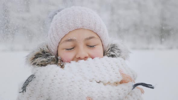 Many Snowflakes Fall on the Face of a Smiling Girl in Winter Time alt