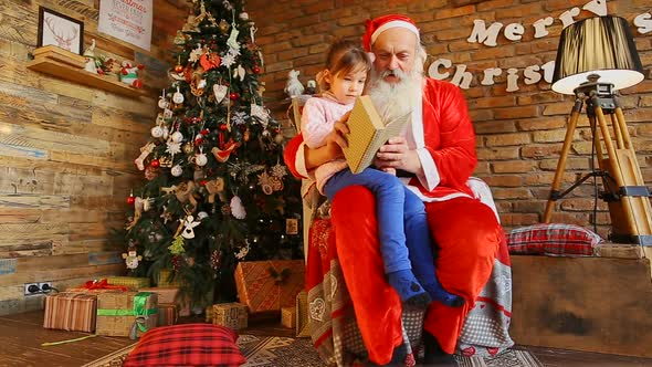  Little European Girl Sitting on Knees at Santa Claus.