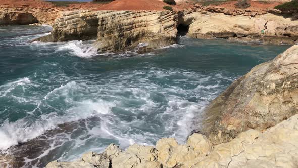 The sea waves beat against the rocks. View of the crystal clear sea, layered rocks and beautiful nat