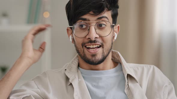 Closeup Arabic Young Bearded Guy with Glasses Speaks Online Call Using Wireless Modern Headphones alt