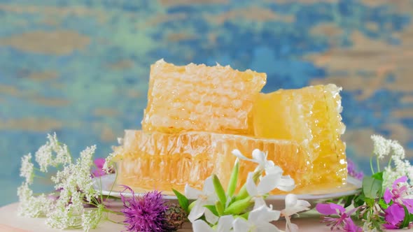 The Honeycombs with Fresh Honey Rotate Slowly on the Rustic Background alt