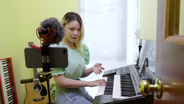 A pianist singing and playing piano online and live past her smartphone