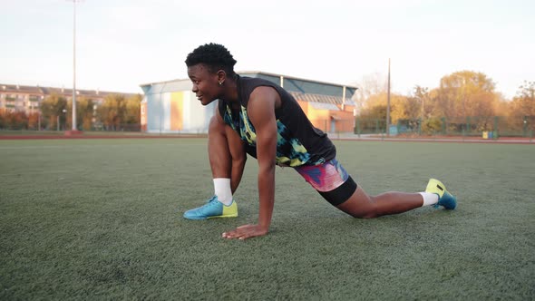 A Young African American Woman Training in a City Stadium on a Sunny Fall Day and Does a Deep Lunge
