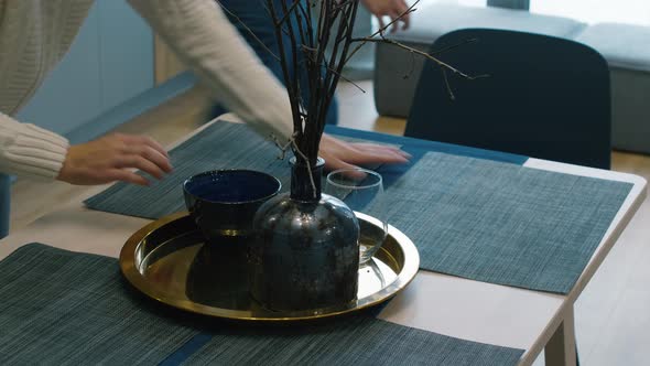 Woman Decorating Table with Vase and Glassware