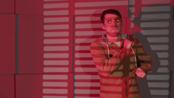 Happy Man in Glasses Dancing Near Wall with Shadows of Jalousie alt
