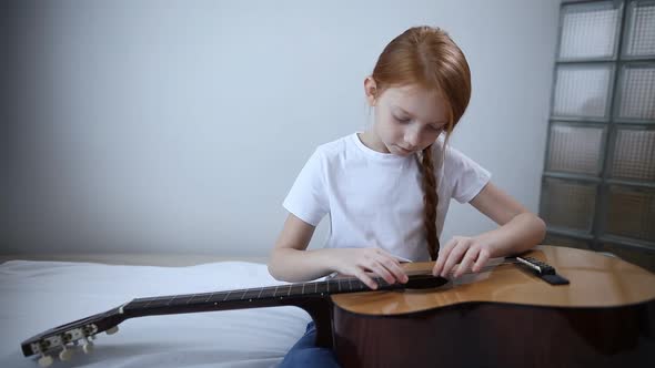 Cute Teenage Girl Blogger with a Guitar in Her Hands Speaks To the Camera, Tells How She Learned To alt