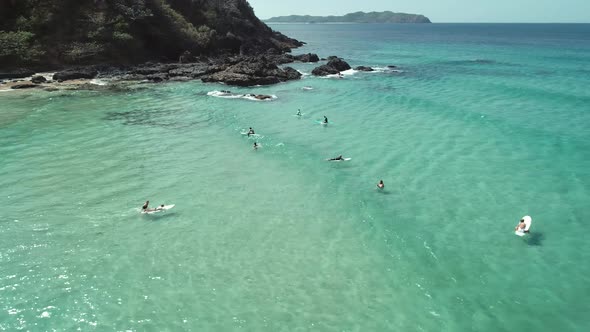 Top View of Waves Break on Tropical White Sand Beach and Surfers with Surfing Boards alt