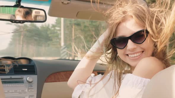 Young beautiful and smiling hipster girl in convertible car alt