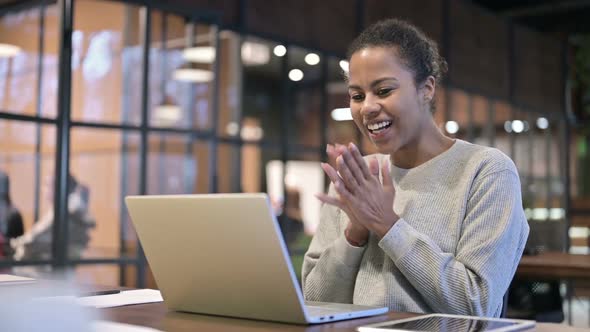 Excited African Woman Celebrating Success on Laptop alt