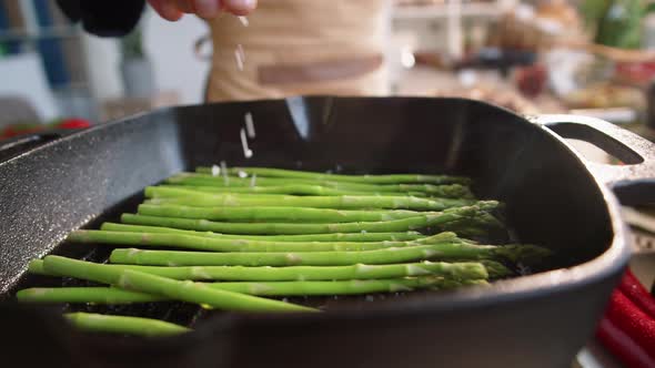 Chef Salting Asparagus on Grill Pan alt