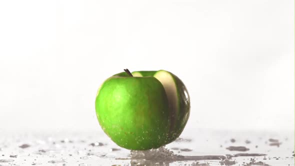 The Super Slow Motion Green Apple Falls on the Table and Splits Into Half alt